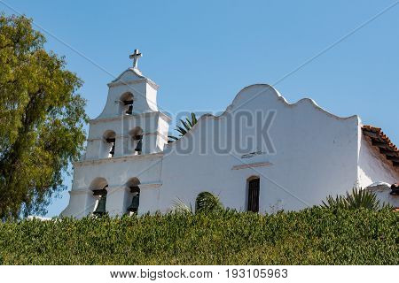 SAN DIEGO, CALIFORNIA - JUNE 24, 2017:  Church facade and bell tower of Mission Basilica San Diego de Alcala, the first Franciscan mission in The Californias, founded by Spanish friar Junipero Serra.