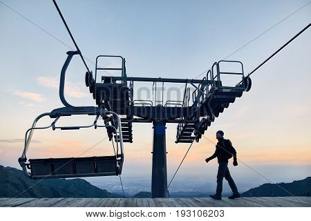 Tourist Near Cable Car In The Mountains