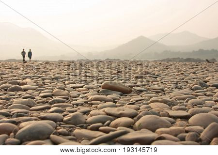 Landscape of stone with sunrise on mountain and two people walking background