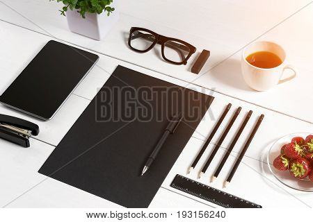 Modern workplace with digital tablet computer and mobile phone, cup of coffee, pen and empty sheet of paper. Top view and copy space for text