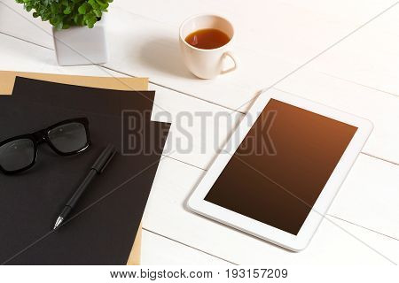 Modern workplace with digital tablet computer and mobile phone, cup of coffee, pen and empty sheet of paper. Top view and copy space for text