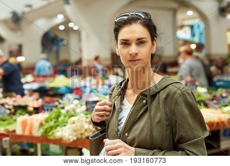 Young woman at greengrocer's shopping for fruits and vegetables.
