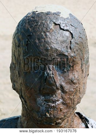 rusted statue head on the beach in crosby anthony gormley another place