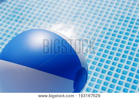Blue and white beach ball floating in a swimming pool