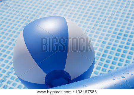 Blue and white beach ball floating in a swimming pool