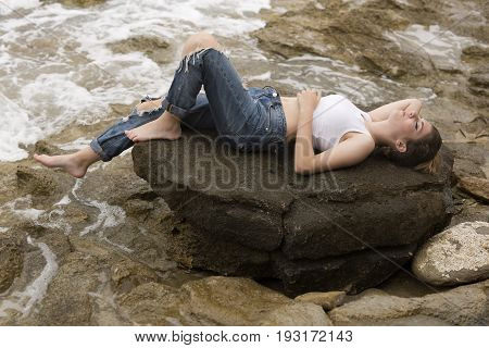 Teenage Girl Lying On The Rocks