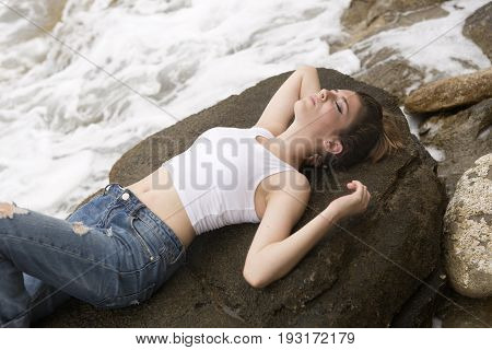 Teenage Girl Lying On The Rocks