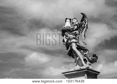 Angel statue holding the Holy Column looks at the heavenly sky on Sant'Angelo Bridge in the center of Rome (Black and White)