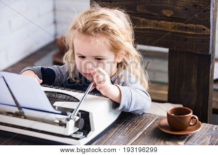 boy or small kid with typewriter paper and coffee cup working at table