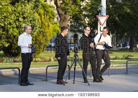 BUDAPEST, HUNGARY. 23 JUNE, 2017: A group of wedding photographers on the streets of Budapest is holding a photo session for a couple of newlyweds.