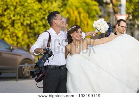 BUDAPEST, HUNGARY. 23 JUNE, 2017: A group of wedding photographers on the streets of Budapest is holding a photo session for a couple of newlyweds.