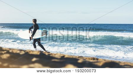 Surfer man holding surfboard on background sea scape sand beach coastline. Panorama horizon perspective view ocean sunlight. Travel summer sport concept backdrop sunny waves seascape mock up
