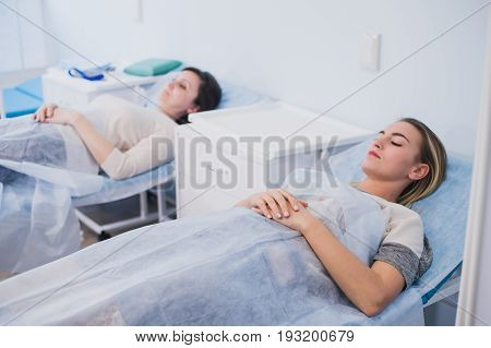 Female patient sleeping in medical bed at the hospital ward.