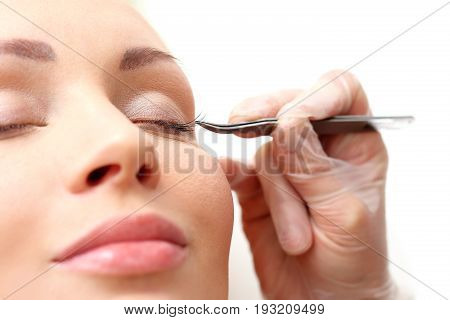Eyelash styling. The beautician prolongs and thickens eyelashes.