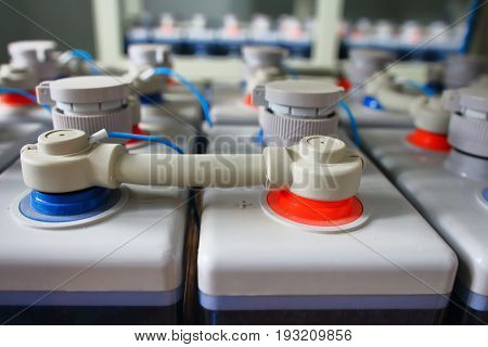 Rows of electric DC battery industrial powerful station supply for equipment. Electrical DC battery power direct current plus minus