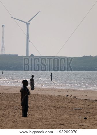 windmills and statues by anthony gomley on crosby beach in mersyside