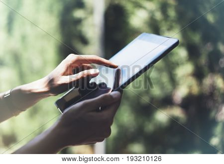 Hipster young girl with bright backpack and vintage camera using tablet or holding gadget planning travel plan. View tourist traveler in background Parc Laberint Barcelona. Mock up for text message