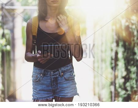 Hipster young girl with bright backpack and vintage camera using tablet or holding gadget planning travel plan. View tourist traveler  background Parc Laberint Barcelona. Mock up for text message