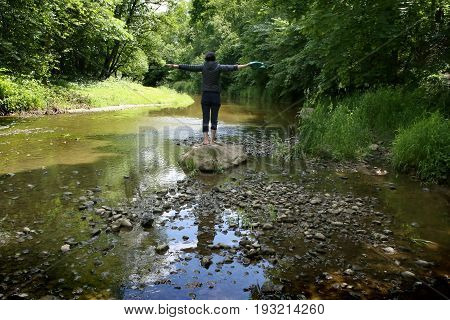 Woman In Wild Nature.  Woman Standing On Stone In Stream In Summer.