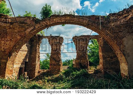 Ruins of church of Michael the Archangel in Yelets, overgrown arc of red brick and ruined columns