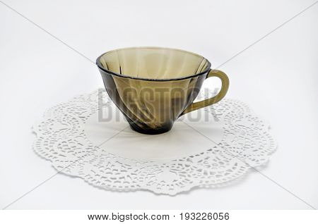 black glass small Cup on a white Lacy napkin on a white background