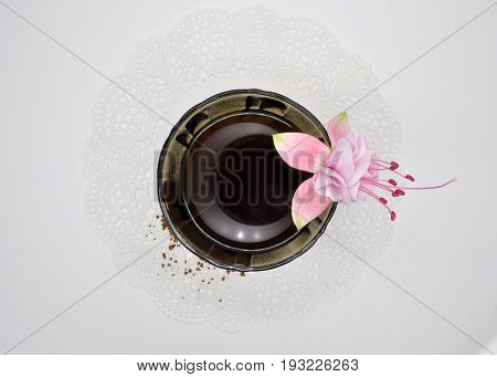 black glass small Cup on a white Lacy napkin on a white background