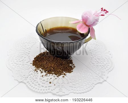 black glass small Cup on a white Lacy napkin on a white background