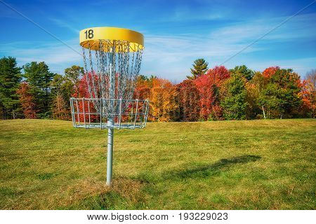 Disc golf hole basket in an autumn park