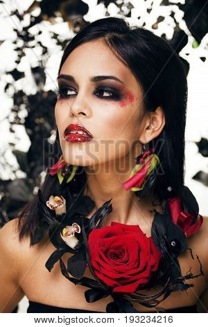 pretty brunette woman with rose jewelry, black and red, bright make up kike a vampire closeup red lips, halloween concept