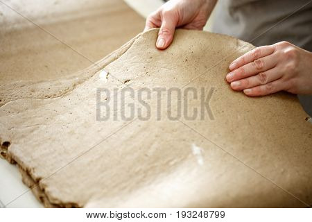 the Baker rolls rye puff pastry on special equipment. blank dough for baking in the bakery