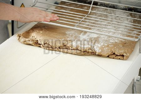 the Baker rolls rye puff pastry on special equipment. blank dough for baking in the bakery
