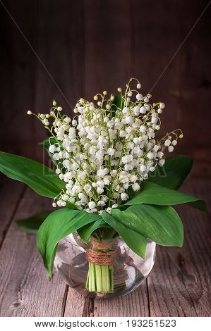 Lilly Of Valley In Glass Vase On Wooden Table