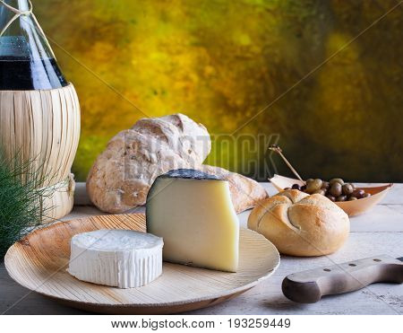 Italian slow food on the white table. Olives cheese bread and red wine