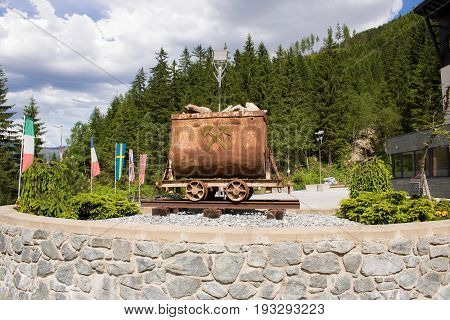 Bad Gastein Austria - JUNE 08 2017: Old mining truck in front of the Health resort Heilstollen a former mining tunnel. Near Bad Gastein Austria Europe. Hammer and pick as symbols of mining.