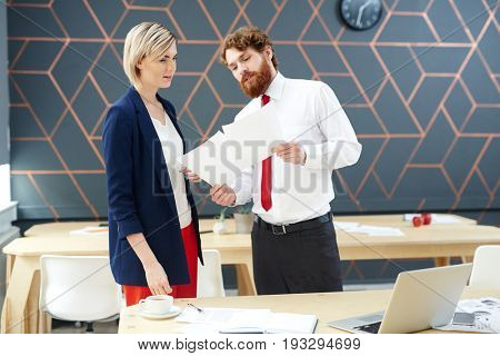 Business leader showing papers to young emloyee