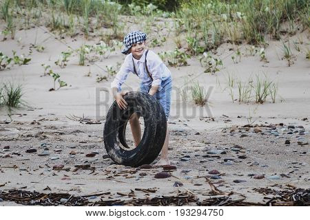 the boy at the top of an old tyre