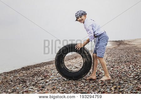 the boy at the top of an old tyre