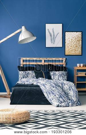 Bed with wooden bedhead on blue wall