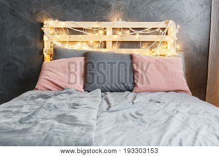 Cozy dreamy bed with decorated DIY pallet headboard