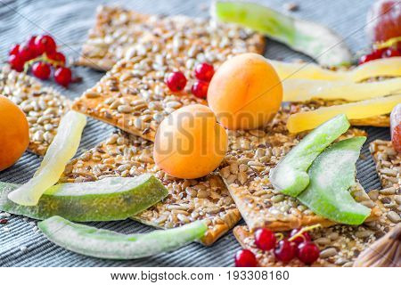 Ripe pricots, dry fruits in sugar, red currant and crispy crackers with seeds