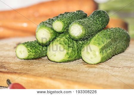 Fresh green cucumber on wooden cutting board