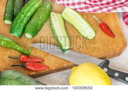 Fresh green cucumber on wooden cutting board