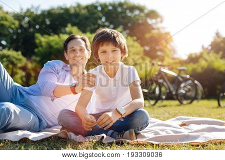 I got your back. Pleasant inspired cool dad and his son taking the bikes and having a ride outside the city while making a stop for some rest