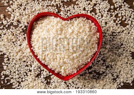 White Grated Corn Kernels In Wooden Bowl. Canjica / Mungunza