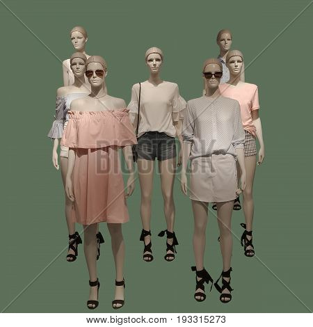 Group of female mannequins wear fashionable summer clothes isolated on green background. No brand names or copyright objects.