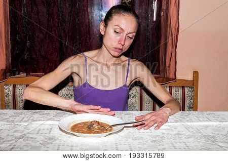 Anorexia. Young skinny woman with anorexia refusing to eat.