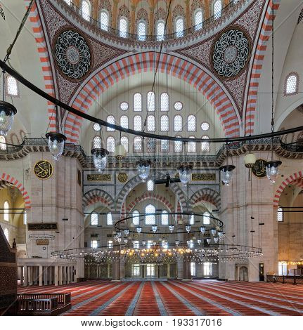 Istanbul, Turkey - April 19, 2017: Interior of Suleymaniye Mosque, an Ottoman Baroque style mosque completed in 1755, with huge arches & many colored stained glass windows, Fatih district
