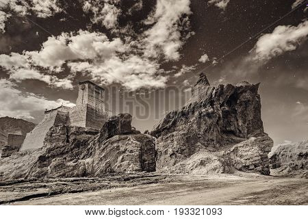 Ruins and Basgo Monastery surrounded with stones and rocks sky with clouds in the background Himalayan Mountain range Leh Ladakh Jammu and Kashmir India - tinted stock image of Indian monasteries