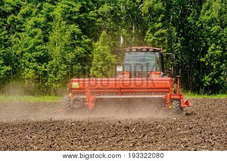 Farmer Seeding Crops On Tractor At Field. Russia