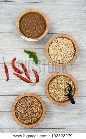 Wheat Berries Buckwheat Groats Pearl Barley Farrow in Bowls with Red Peppers on the side